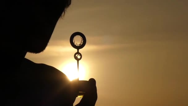 Het silhouet van Man Blow bubbels bij zonsondergang. Mooie actie in Slow Motion. — Stockvideo