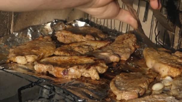 Hand med tång för sätta kött på grillen. — Stockvideo