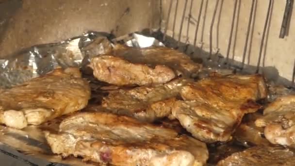 Mano utilizzando pinze per accendere la carne alla griglia . — Video Stock