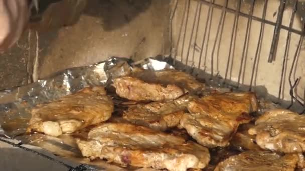 手用火钳在烤架上的车削肉. — 图库视频影像