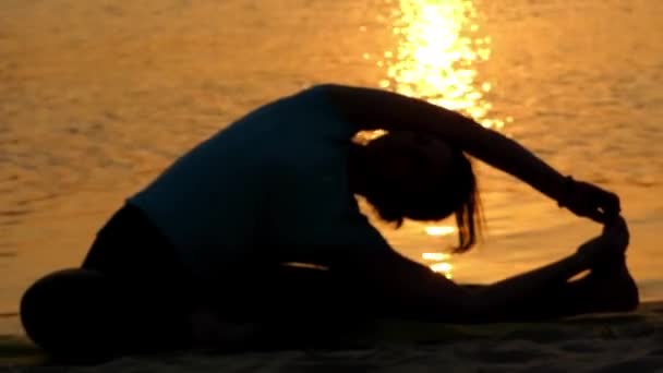 Chica haciendo estiramiento en la playa . — Vídeos de Stock