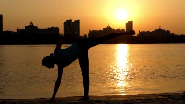 Kız yapmak Yoga Poses batımında sahilde. — Stok video