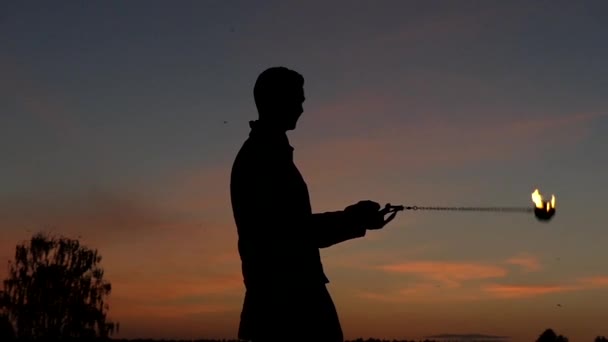 Feuershow bei Sonnenuntergang. Der Mensch verwendete Poi, um schöne Effekte zu erzielen. Zeitlupe. — Stockvideo