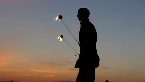 Spectacle de feu au coucher du soleil. Homme utilisé Poi pour faire de beaux effets. Mouvement lent . — Video