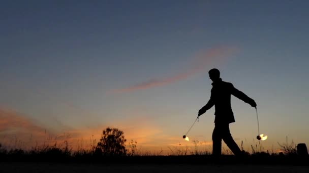 Espantoso show de fogo ao pôr-do-sol. Homem do circo a trabalhar com Fire Poi. Movimento lento . — Vídeo de Stock