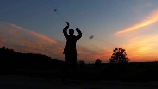 O Circus estava a fazer um espectáculo ao pôr-do-sol. ele torce nas mãos do Poi. Movimento lento . — Vídeo de Stock