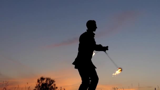 Erstaunliche Feuershow bei Sonnenuntergang. Zirkusmann, der mit Feuerpoi arbeitet. Zeitlupe. — Stockvideo