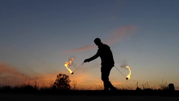 Fantastisk eldshow i solnedgången. Cirkus Man arbetar med eld Poi. Slow Motion. — Stockvideo