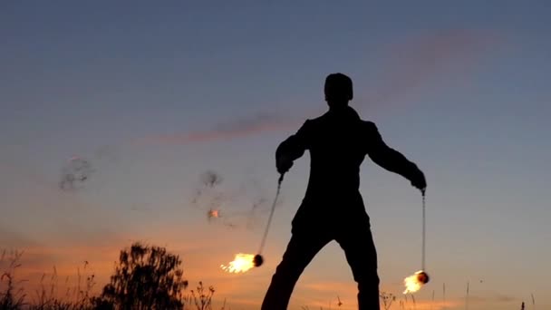 Erstaunliche Feuershow bei Sonnenuntergang. Zirkusmann, der mit Feuerpoi arbeitet. Zeitlupe. — Stockvideo