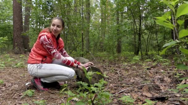 Mooie meisje in het bos roept eekhoorn. Ze stoten een moer op de boom. — Stockvideo
