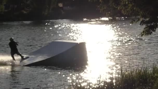 Un Wakeboarder saute sur le Wakeboard au-dessus du Springboard. Mouvement lent . — Video