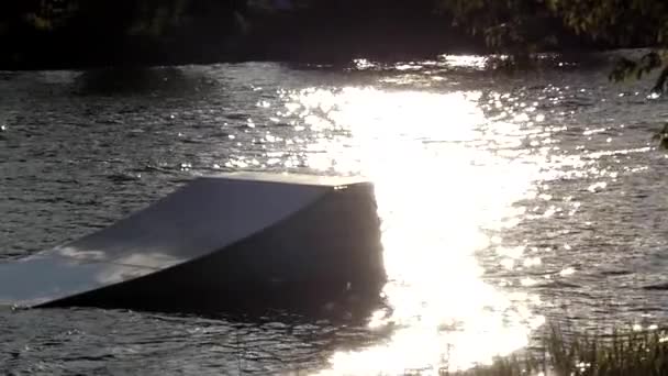 Un Wakeboarder saute sur le Wakeboard au-dessus du Springboard. Mouvement lent . — Video
