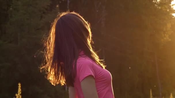 Une jeune fille au ralenti secouer la tête et jouer avec les cheveux. l'action a lieu au coucher du soleil . — Video