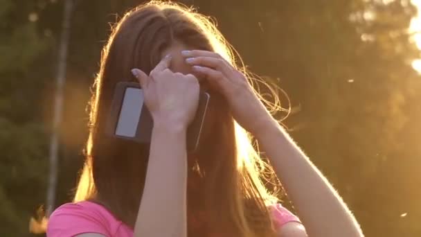 Una joven en cámara lenta agitar la cabeza y jugar con el pelo. la acción tiene lugar al atardecer . — Vídeos de Stock