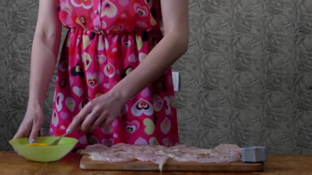 Chica en la cocina golpeando huevos con un tenedor en un tazón . — Vídeo de stock