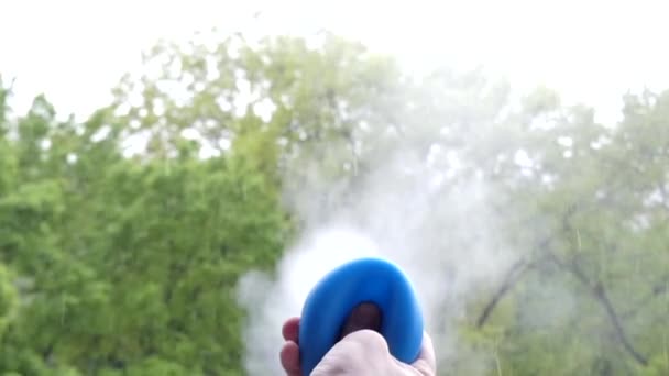 Фокус: рука преси клізму й він випромінює дим від тальку. Повільний рух. — стокове відео