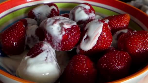 De lepel voorkomt de aardbeien met slagroom. — Stockvideo