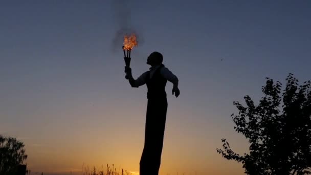 Fantástico espectáculo al atardecer. Circo en Stilts escupe el fuego. Moción lenta . — Vídeos de Stock