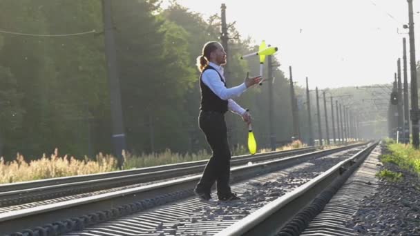 Guy Juggling sulle tracce del treno. Rallentatore. Tramonto. Bilanciamento delle ferrovie . — Video Stock