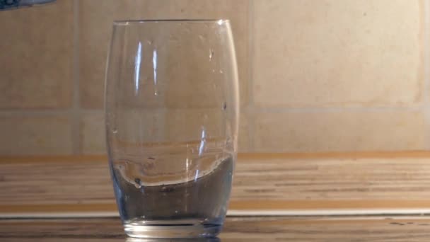 Do sklenice ledové padající vody. — Stock video