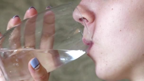 Jeune et belle fille boit de l'eau à partir d'un verre au ralenti. Gros plan . — Video