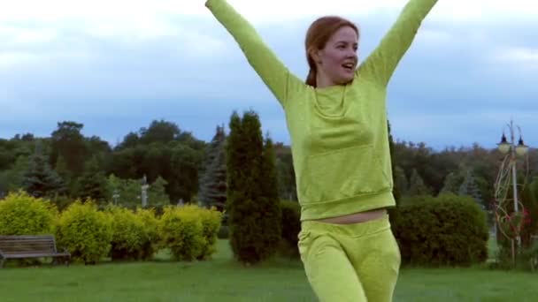 Krásná rusovláska dívka tančí v parku. — Stock video