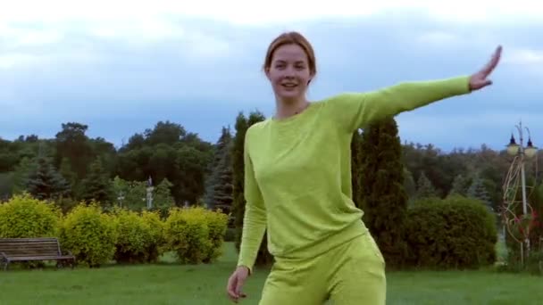 Hermosa pelirroja chica bailando en el parque . — Vídeos de Stock