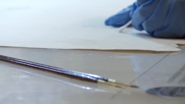 Processen för restaurering av gamla målningar i laboratoriet. Närbild. — Stockvideo