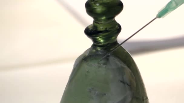 Een injectiespuit met vloeistof en een speciale oplossing druppels op het glas. Close-up. — Stockvideo