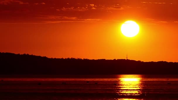 Silhueta de pessoas caminhando ao pôr do sol sobre o mar . — Vídeo de Stock