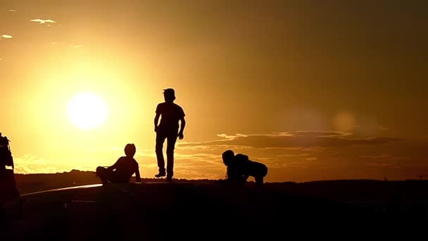 Crianças felizes pulando em um trampolim durante o pôr do sol em câmera lenta . — Vídeo de Stock