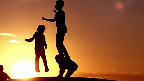 슬로우 모션으로 일몰 시 한 트램 폴 린에 점프 행복 한 아이 들. — 비디오