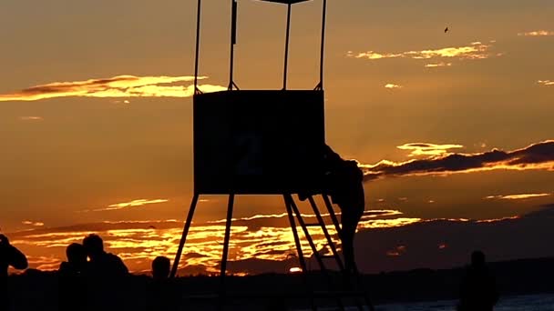 Torre de rescate en el océano durante la puesta del sol . — Vídeos de Stock