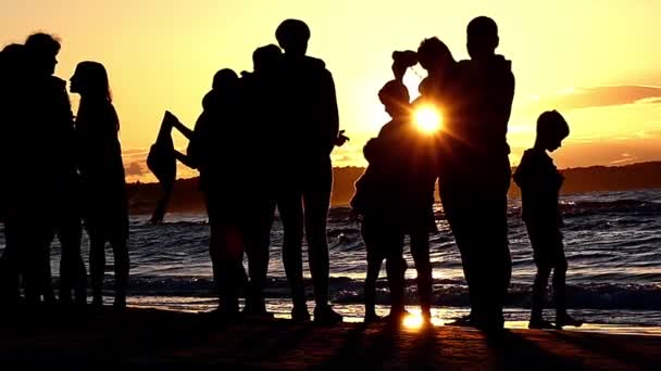 Silhouette människor på Sunset nära havet. Slow Motion. — Stockvideo