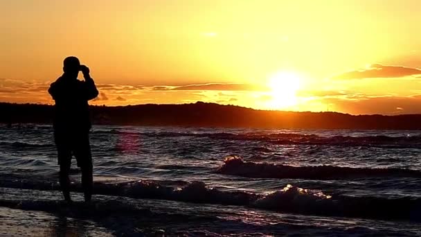 Homem filmando um belo pôr do sol no telefone. Pôr-do-sol incrível e movimento lento . — Vídeo de Stock