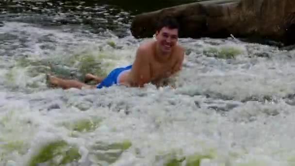 Man Lies in Mountain River and Play With Water (em inglês). Sorria. . — Vídeo de Stock