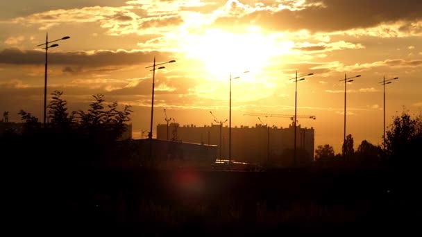 Міський краєвид в режимі реального часу під час заходу сонця. Будинки, крани, будівель, вогні. — стокове відео
