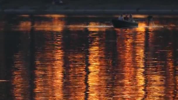 A Small Boat With People Floats on the Lake During Sunset. — Stock Video