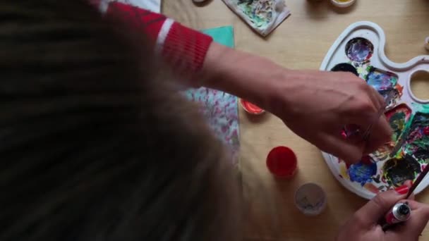 Дівчина малює маленького янгола на полотні — стокове відео