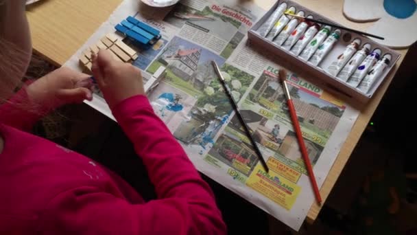 Little girl painting clothespin in blue color. — Stock Video