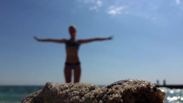 Όμορφη κοπέλα κάνει ένα σώμα ασκήσεις στην παραλία. — Αρχείο Βίντεο
