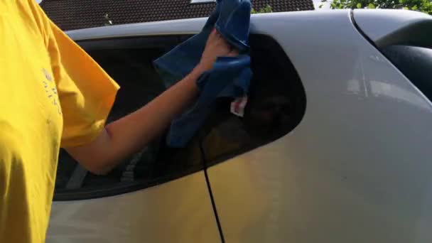 Meisje schoon te maken haar zilveren auto. — Stockvideo