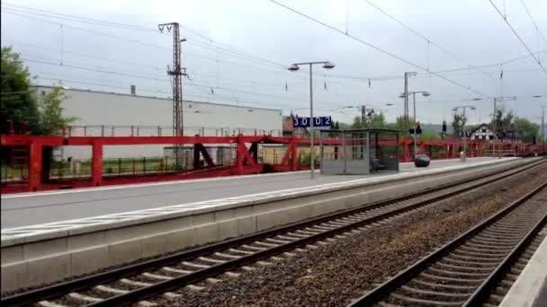 Pusty pociąg do przewozu samochodów przechodzi na peronie dworca. — Wideo stockowe