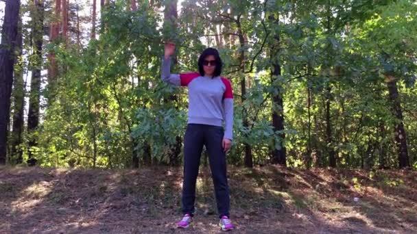 Menina fazendo exercício com as mãos na floresta . — Vídeo de Stock