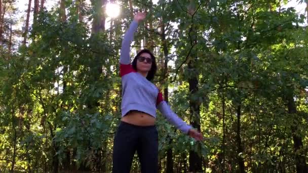 Дівчинка робить вправи в лісі. Розминка . — стокове відео