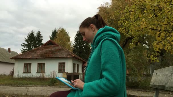 Menina usando tablet azul no parque . — Vídeo de Stock