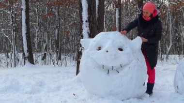 Kız kardan büyük bir kafa yapar. Komik bir figür.
