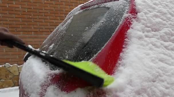 Dziewczyna oczyszcza śnieg na czerwonego samochodu. Akcja w zwolnionym tempie. — Wideo stockowe