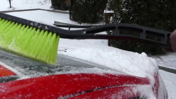 緑のブラシを赤い車に雪の清掃します。リアルタイムでアクション。冬. — ストック動画