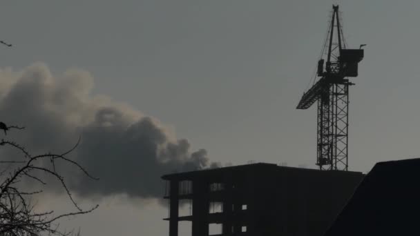 El edificio de la casa. Grúa de silueta sobre el fondo de humo . — Vídeos de Stock